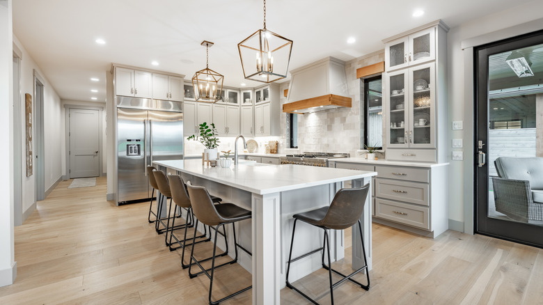 Modern farmhouse kitchen with gray cabinets, an island, and wood flooring