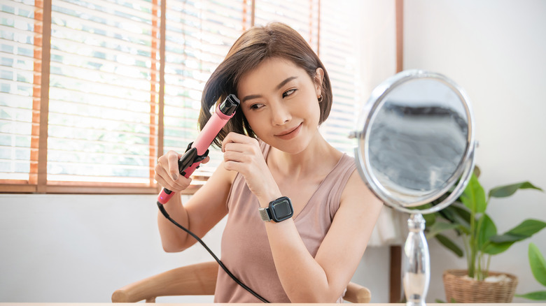 young woman curling hair