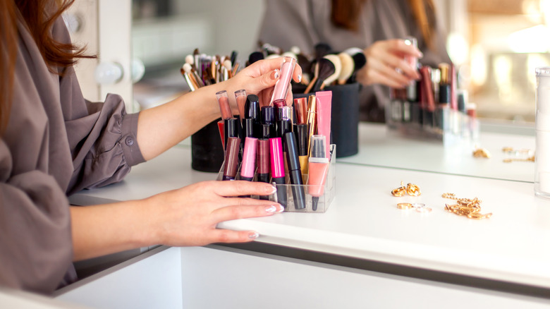 woman organizing makeup on vanity