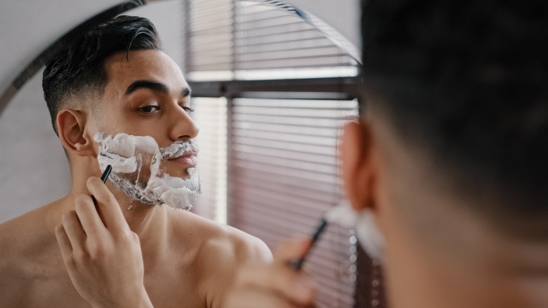 man shaving in mirror