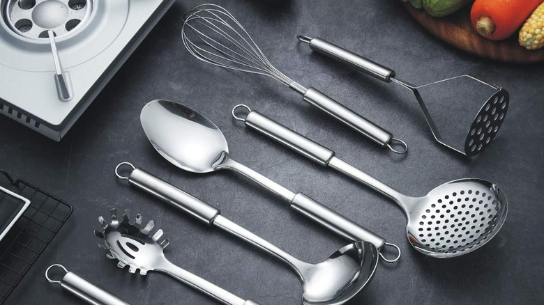 assorted stainless steel cooking utensils on black countertop