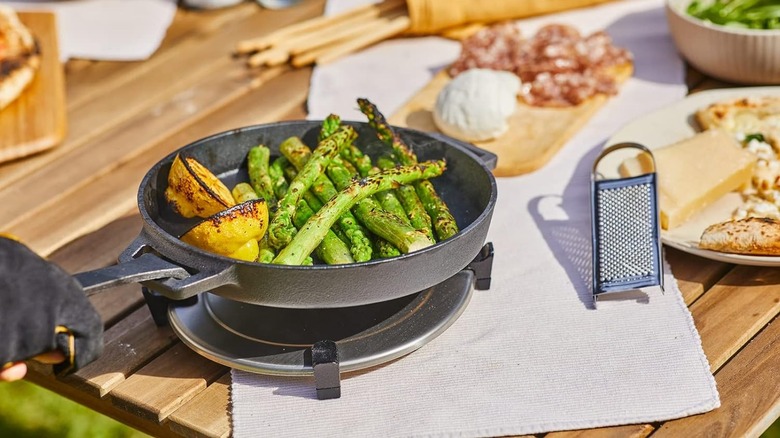 seared asparagus in cast iron pan on wood table