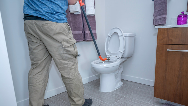 Plumber snaking a toilet