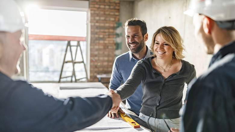 woman shaking contractor's hand