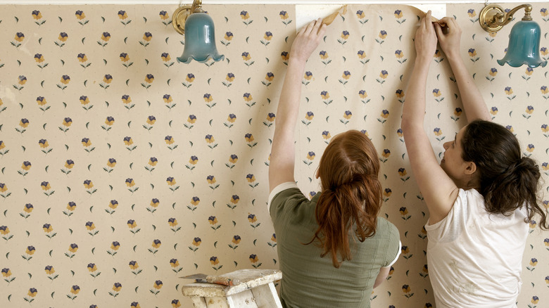 women applying wallpaper