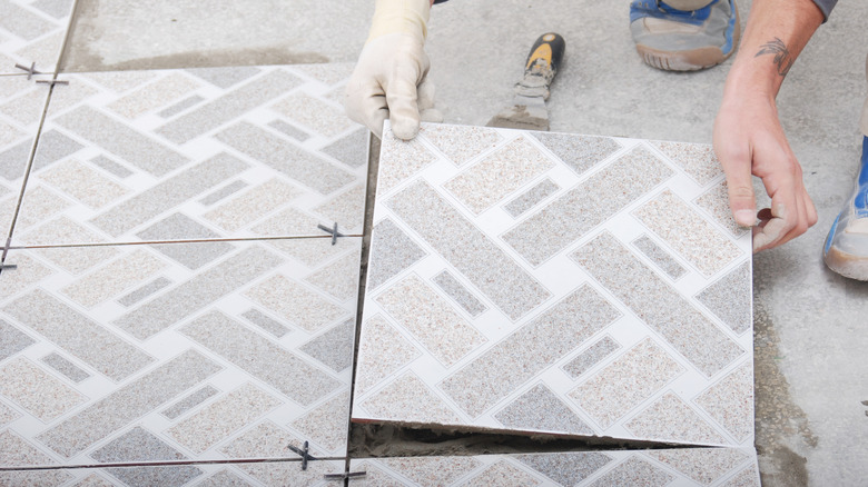 person installing patterned tiles