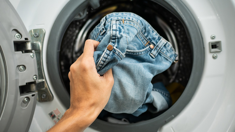 Person removing jeans from washer