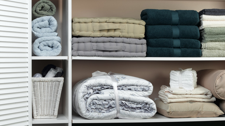 Fresh linens in different colors folded neatly in closet