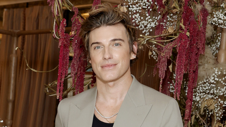 Jeremiah Brent grinning in tan suit jacket