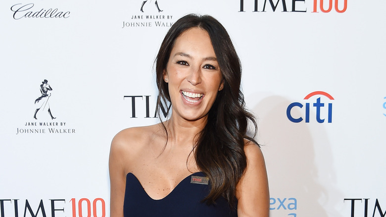 Joanna Gaines smiling in front of red carpet