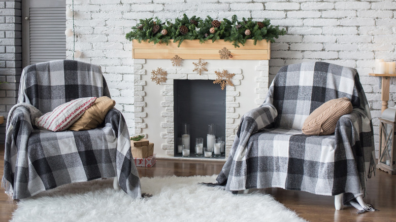 Garland on a fireplace mantle with two chairs on either side