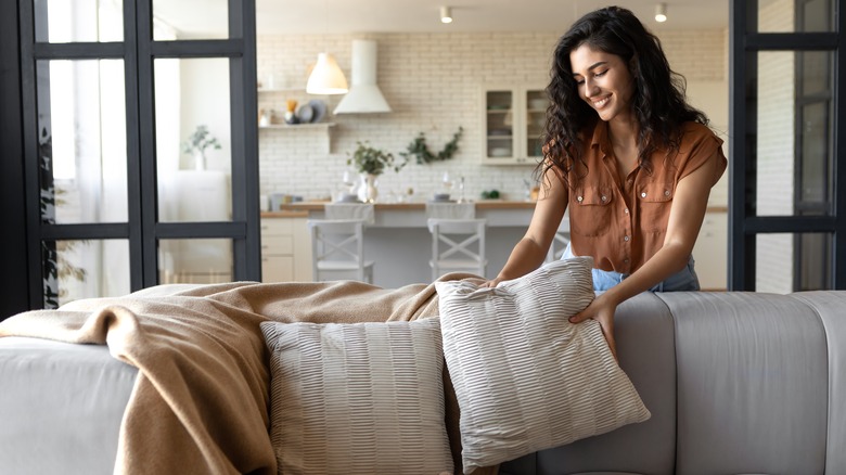 Woman arranging sofa pillows