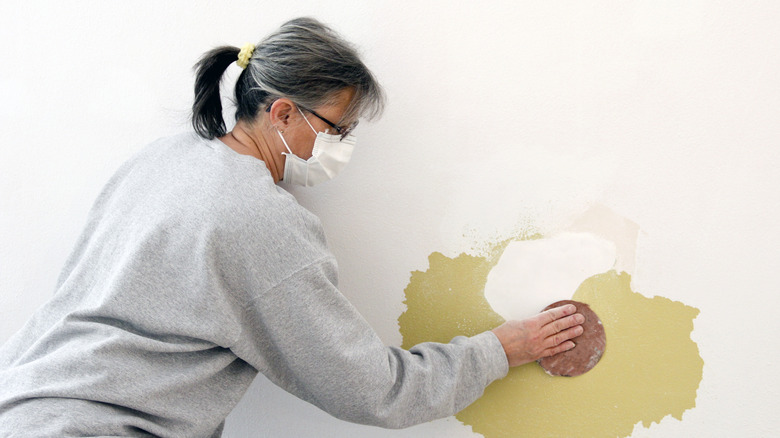 Wearing mask while sanding wall