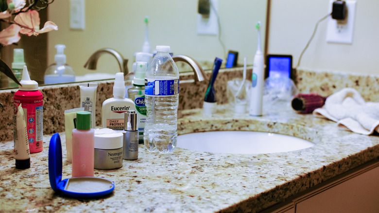 Makeup products and clutter on bathroom countertop