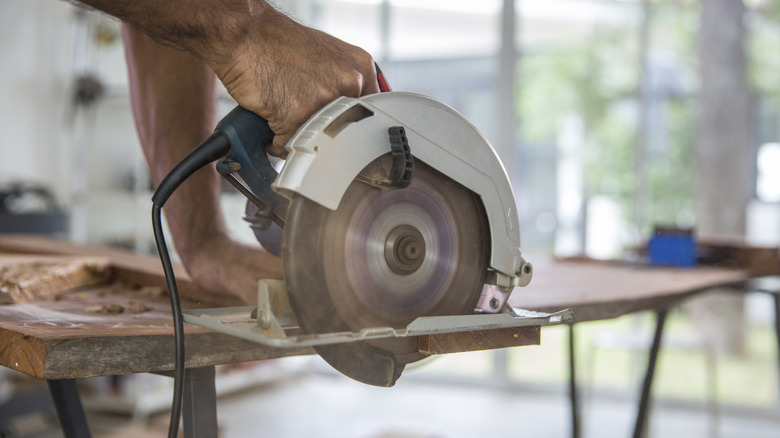 A person uses a circular saw