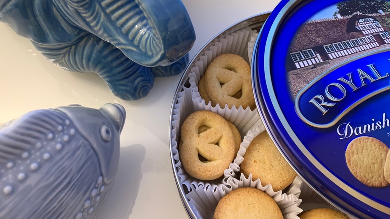 Royal Dansk butter cookie tin and figurines rest on a desktop