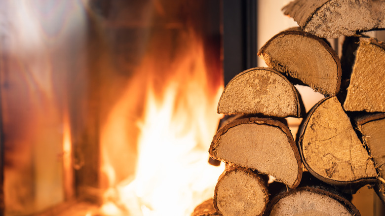 A stack of firewood in front of the fireplace.