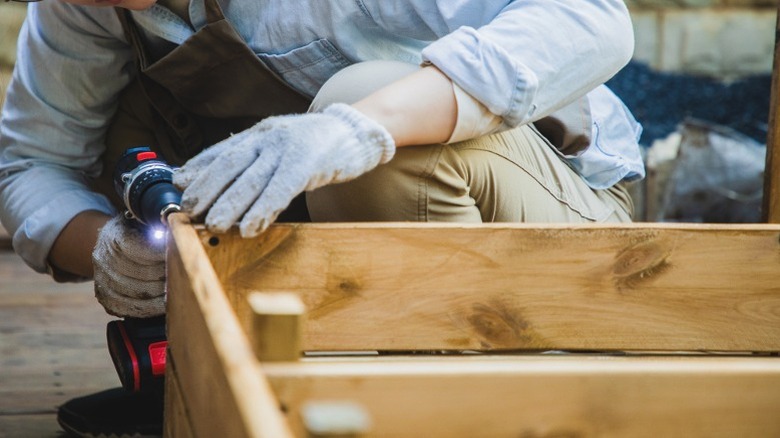 Woman drilling screws into wood planter box