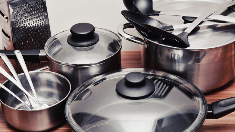 Disorganized pots and pans sitting on the kitchen countertop