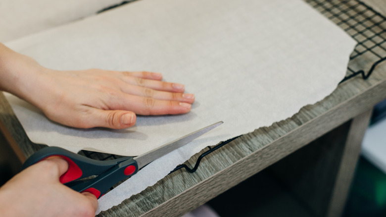 Person cutting parchment paper