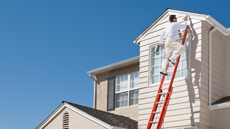 A man painting a house 