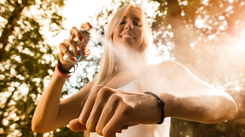 A woman using bug spray