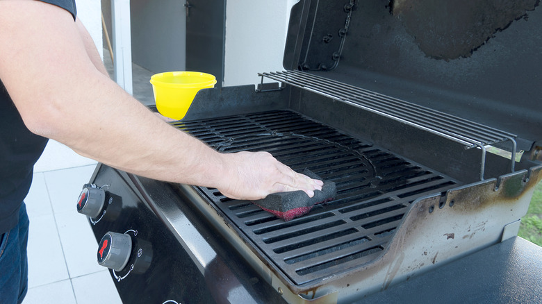 Man scrubbing down grill