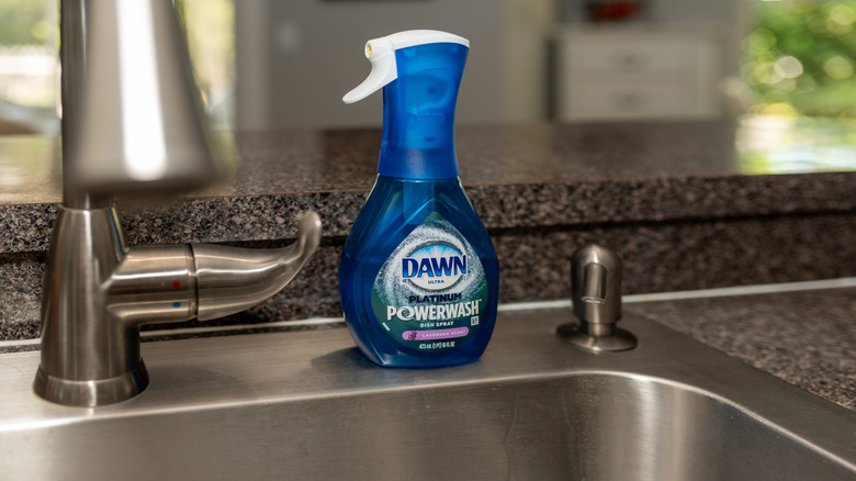 A bottle of Dawn Powerwash sitting on a stainless steel sink