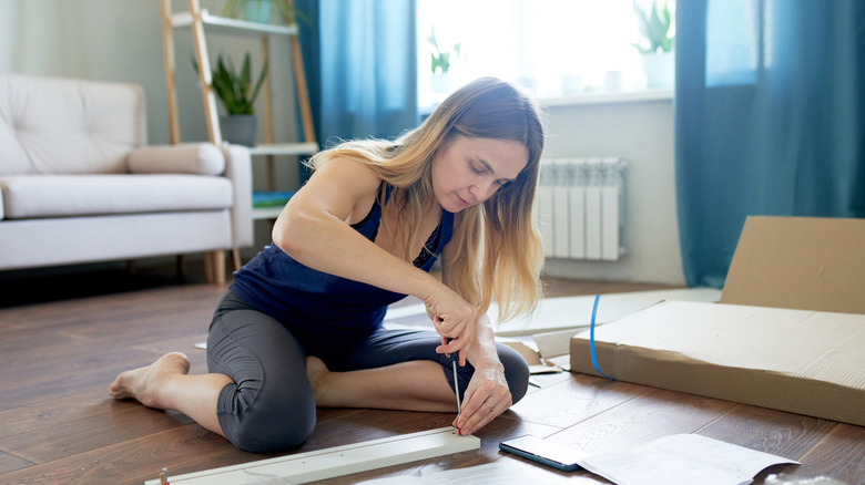 Person putting together IKEA furniture with a screwdriver