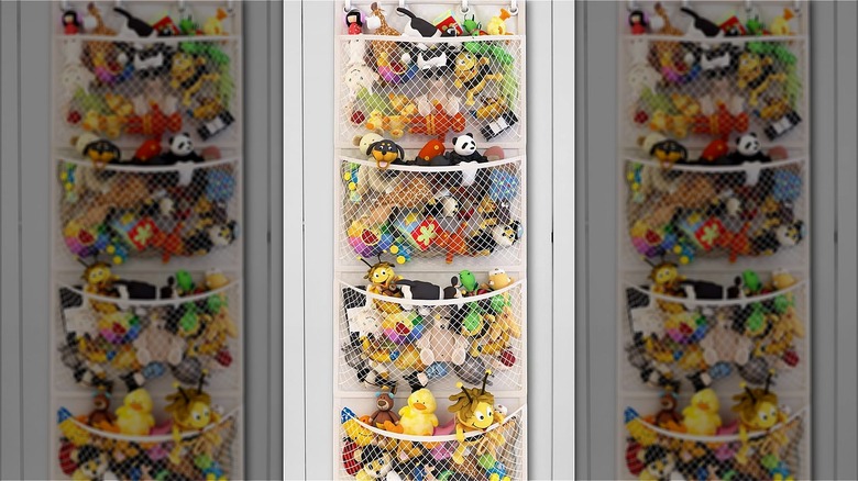 Over-the-door stuffed animal storage with net pockets filled with stuffed animals.