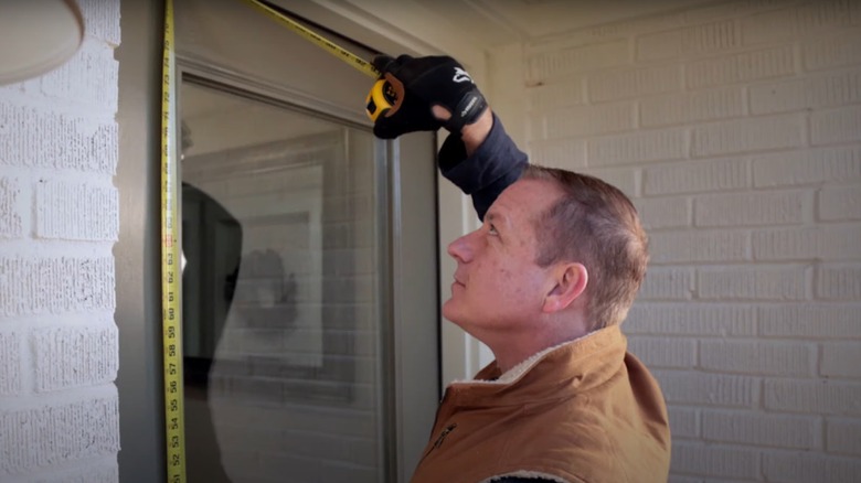 man measuring for a storm door