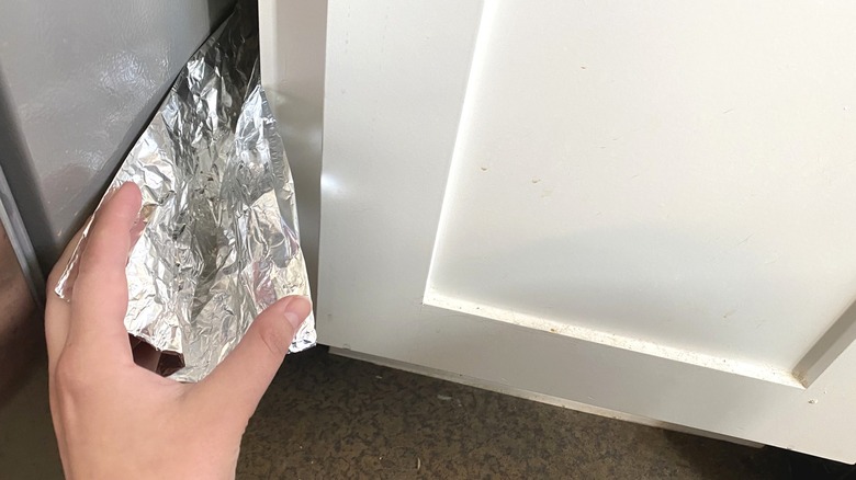 Hand placing foil in crevice