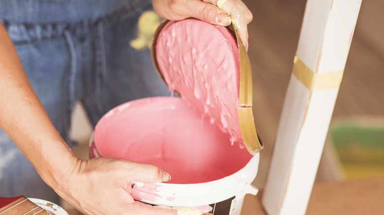 woman opening paint bucket 