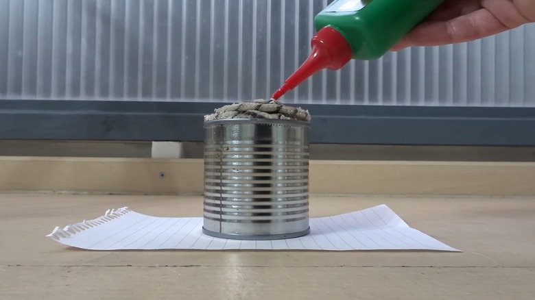 Man adding oil to rag in a metal can