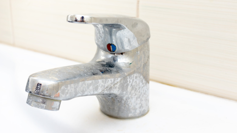 Sink faucet covered in hard water stains