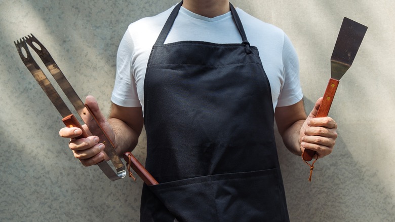 Man holding BBQ tools