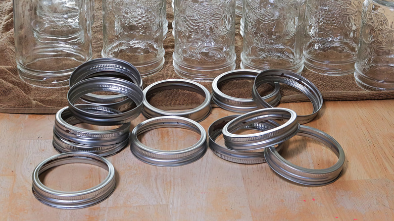 Canning jar lid rings in front of jars on towel