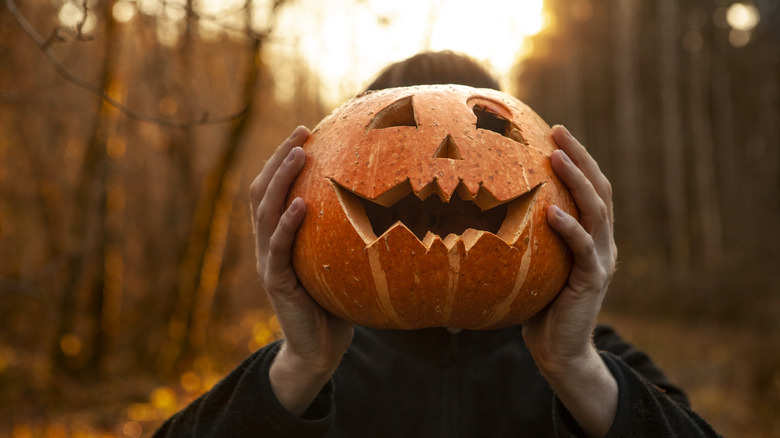 carved pumpkin held up