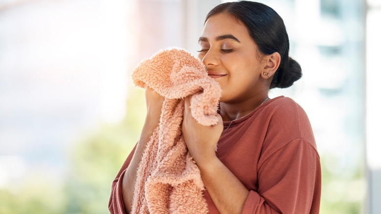 Woman smelling fresh clothes