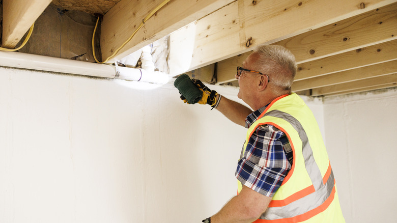 man inspecting floor joists