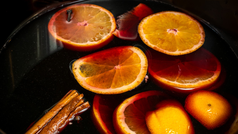 A simmer pot is filled with oranges and cinnamon sticks.