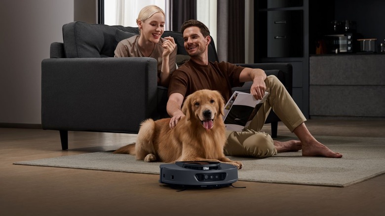 Happy family lounging together in living room with golden retriever and 3i robot vacuum