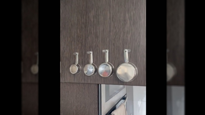 Measuring cups hanging in cabinet