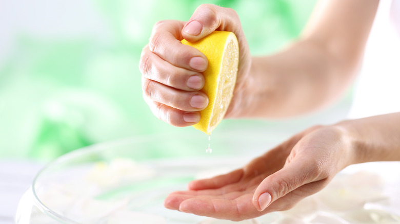 Hands squeezing a lemon