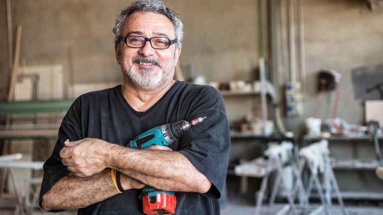 smiling man holding Makita drill