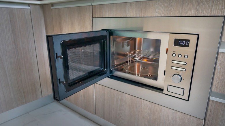 Microwave in cabinet with door open