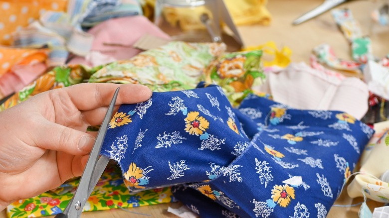 person cutting up fabric scraps