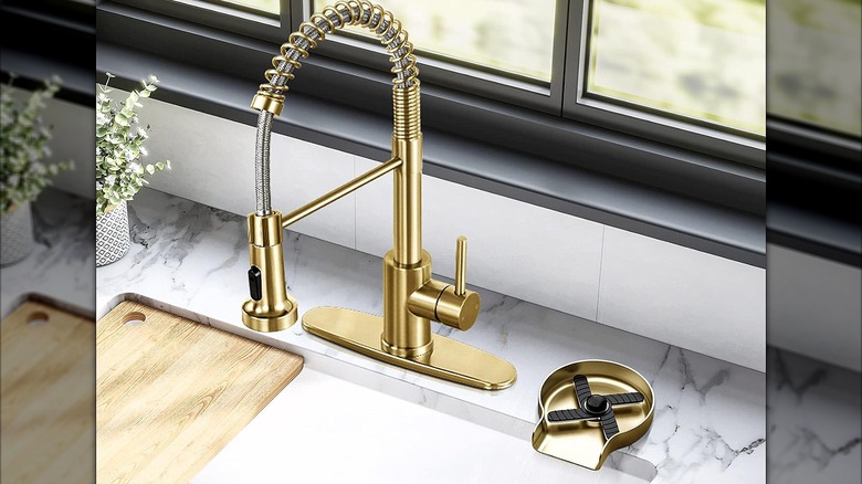 Gold faucet and HGN glass rinser at a kitchen sink