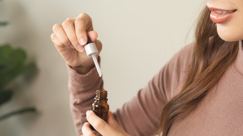 Woman holding bottle of essential oil