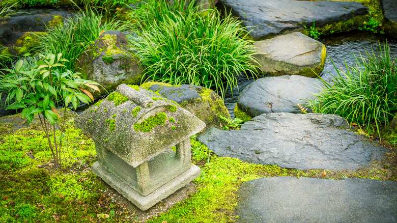 A Japanese garden with a moss-covered ornament